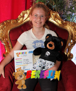 Kuschelbär Benjamin, der schwarze Teddybär, geht in seinem Panda-Pyjama und Panda-Hausschuhen ins Lager